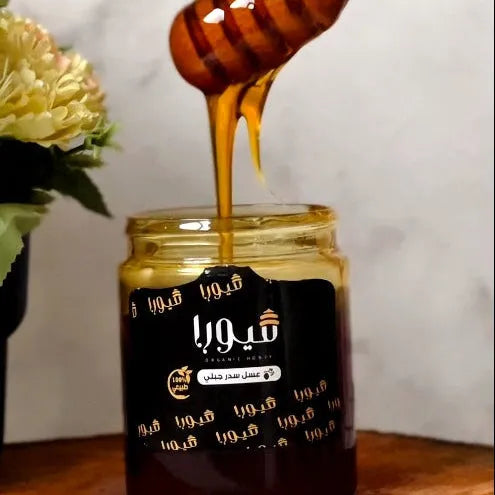 Jar of honey with a wooden dipper, white background